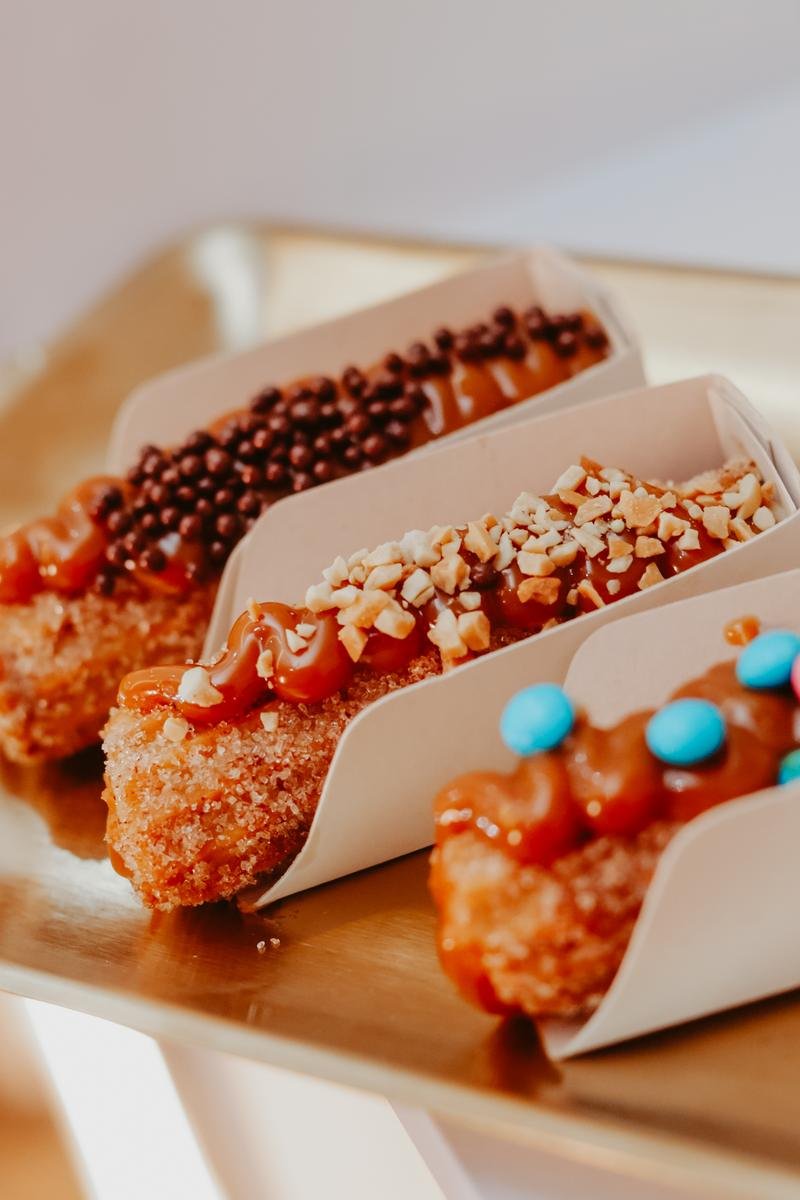 Churros gourmet finalizados com caldas e toppings